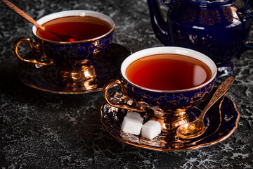 Vintage tea pair with teapot on a dark background