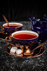 Vintage tea pair with teapot on a black background