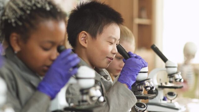 lesson in a modern school, kids look at microscopes in a chemistry lesson, the process of teaching children in a modern school.