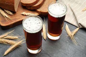 Glasses of delicious kvass, bread and spikes on black table