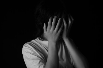 手で顔を覆う女性