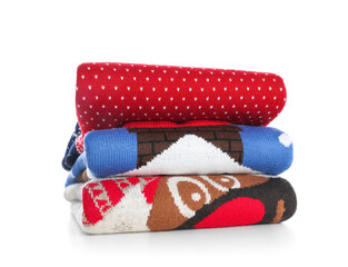 Stack of warm Christmas sweaters isolated on white