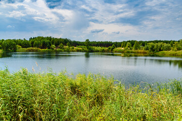 View on a lake in the abandoned sand quarry and dramatic sky