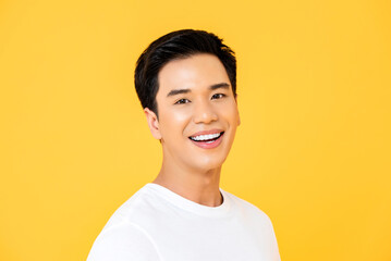 Close up portrait of young handsome Asian man cheerfuly smiling and looking at camera in isolated...