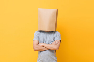 Concept portrait of Anonymous man with head covered with paper bag doing arms crossed gesture in...