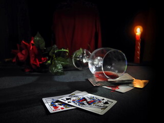 Obraz na płótnie Canvas Cards and wine. Playing the card and a tumbled glass in red wine.