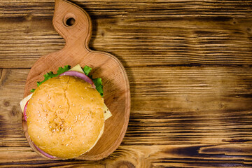 Fresh hamburger on a wooden cutting board. Top view