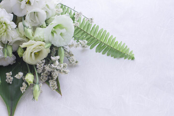 Flower arrangement of several kinds of white flowers and leaves.