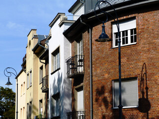 Fototapeta na wymiar apartment buildings in Budapest, Hungary. Brick facade. classical residential elevations. wrought iron balcony with chairs. retro style street lamps, white windows. blue sky. closeup view. copy space