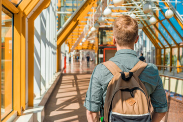 Obraz premium A young man with a backpack walks on a futuristic yellow pedestrian bridge in Moscow