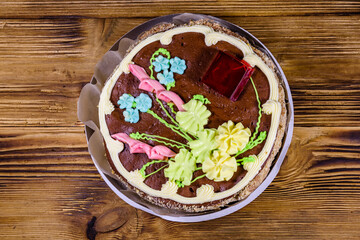 Kiev cake with cream, nuts and meringue in cardboard box on a wooden table. Top view
