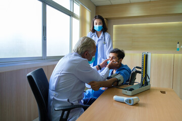 Obraz premium The doctor examined the patient in the wheelchair
