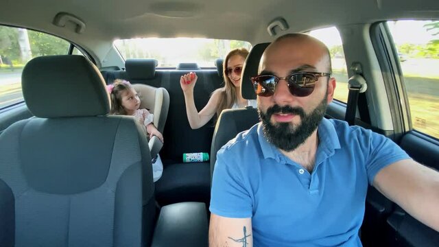 Beautiful family of three enjoying at driving a car and going on road trip