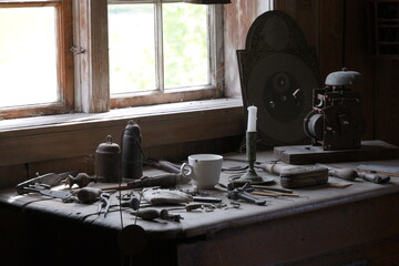 Old craftsman's desk by the window with various tools.