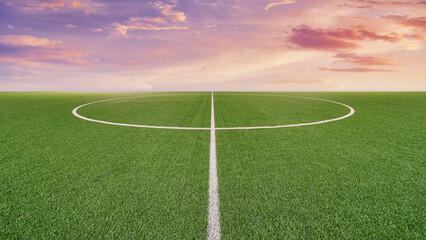 Obraz premium Beautiful green football field. with dramatic sunset in distance background. Concept for creative sport poster or advertising use.