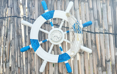 blue and white clock anchor on a wooden background at the beach © Yasmina