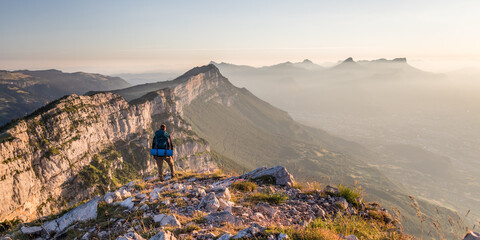 man standing face to the mountains during sunrise over grenoble