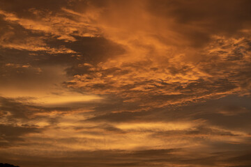 Naklejka na ściany i meble Orange clouds in the sky during the sunset