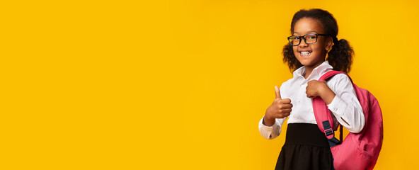 Smiling African Schoolgirl Gesturing Thumbs-Up Approving School, Yellow Background, Panorama