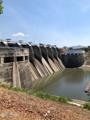 a water dam that stands firm and towers high, to accommodate and regulate the flow of river water from various directions, a dam that looks sturdy and majestic.