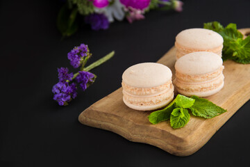 Fototapeta na wymiar Macarons and mint for dessert - healthy organic summer dessert. Creative atmospheric decoration.