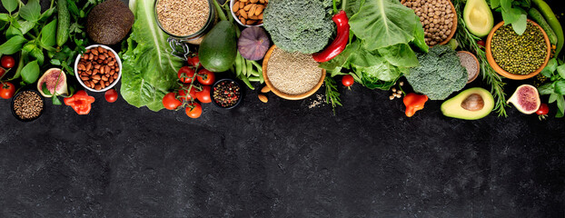 Obraz na płótnie Canvas Fresh vegetables, fruits and cereals on a black background, top view, copy space. A balanced vegetarian diet.