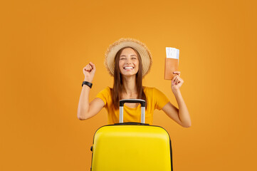 Excited girl with luggage holding passport and flight tickets