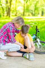 Mother calms her son who falling from a bicycle