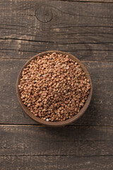 Buckwheat groats on wooden background. Healthy cereal concept.  