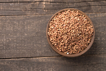 Buckwheat groats on wooden background. Healthy cereal concept.  