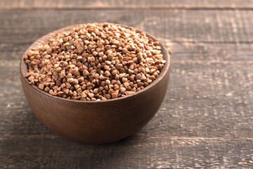 Buckwheat groats on wooden background. Healthy cereal concept.  