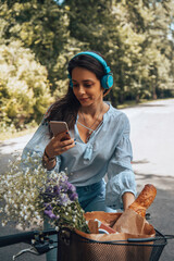 Stylish woman riding a bicycle and using a cellphone.