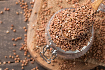 Buckwheat groats on wooden background. Healthy cereal concept.  