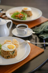 Obraz na płótnie Canvas Fried rice served with fried egg and a cup of coffee
