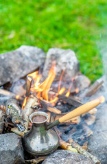 Turkish cezve stands on bonfire. Empty space for text
