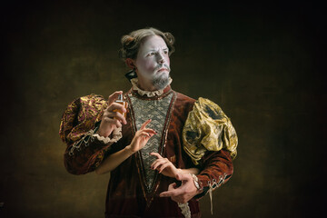 Disinfecting hands. Young man as Johann Bach isolated on dark green background. Retro style,...