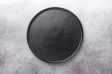 Empty black ceramic plate on stone background Copy space Top view
