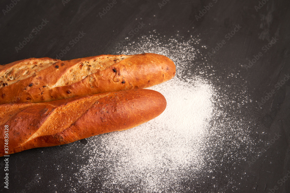 Wall mural Two crispy french baguettes lie on an old wooden table with free space for text