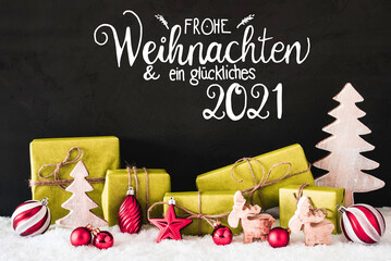 German Calligraphy Frohe Weihnachten Und Ein Glueckliches 2021 Means Merry Christmas And A Happy 2021. Green Christmas Present With Decoration Like Reindeer, Tree and Ball. Black Background With Snow