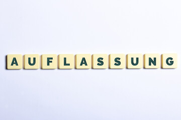 Das Wort Auflassung in Buchstaben auf weißem Hintergrund