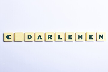 Das Wort Darlehen in Buchstaben auf weißem Hintergrund und Euro Zeichen