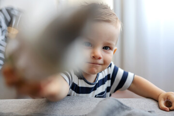 Fototapeta premium Closeup of cute blond toddler reaching for the camera.