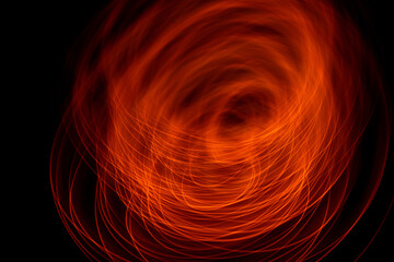 Light wave trail path, vibrant neon gold color in abstract swirls on a black background. Light painting