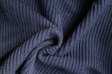 Pleats on fabric, knitted material of dark blue color, folds