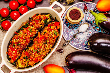 Karniyarik traditional Turkish food from stuffed eggplants with minced meat, tomato, greens and sesame seeds