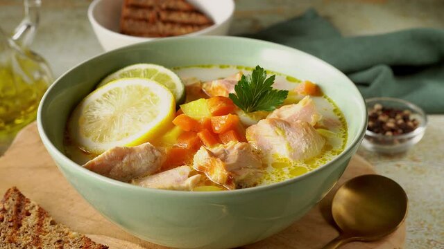 Close up of a plate with delicious and healthy salmon soup on wooden board. Movement from bottom to top. 4K UHD