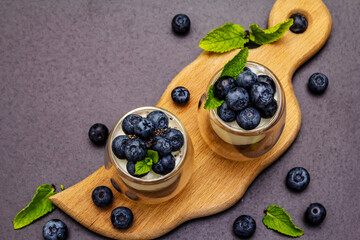 Naklejka na ściany i meble Yogurt with blueberries and chia seeds on wooden cutting board