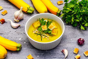 Yellow zucchini cream soup. Healthy vegan (vegetarian) food, crispy toast, sunflower seeds, whole ripe fruits, fresh greens