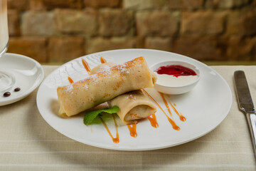 Freshly made pancakes with jam and sour cream.