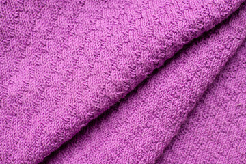 Pleats on fabric, knitted material of purple color, folds